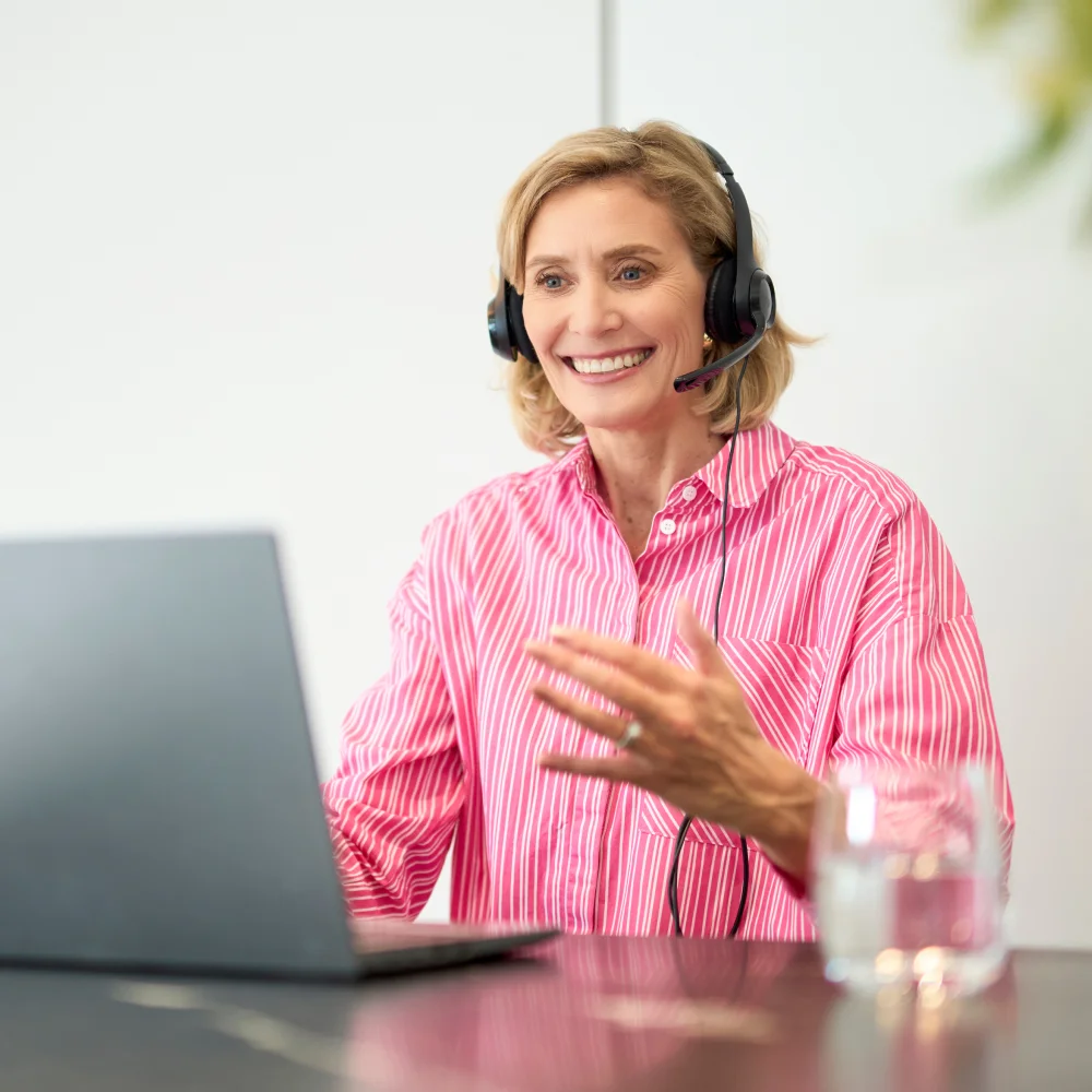 photograph of a woman smiling on a laptop