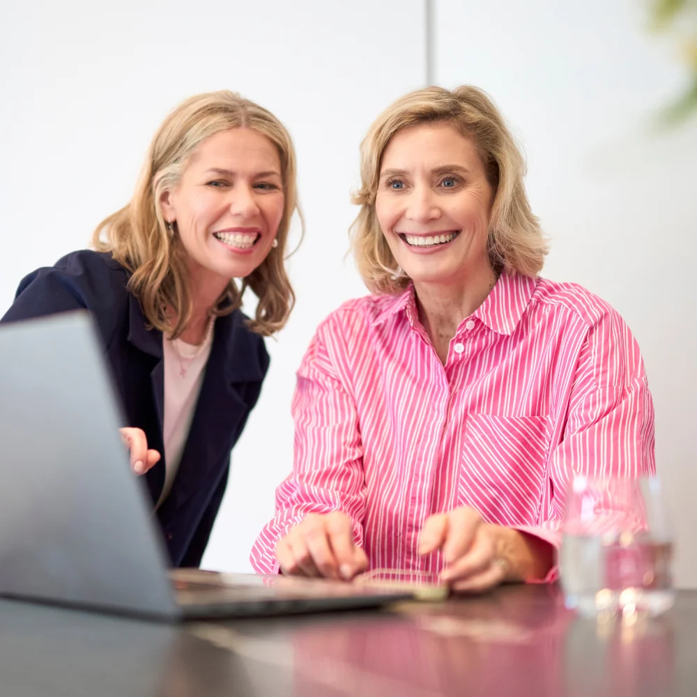 photograph of two people on a laptop